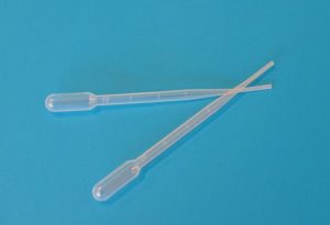 Two pipettes lying on a table in a V-shape.